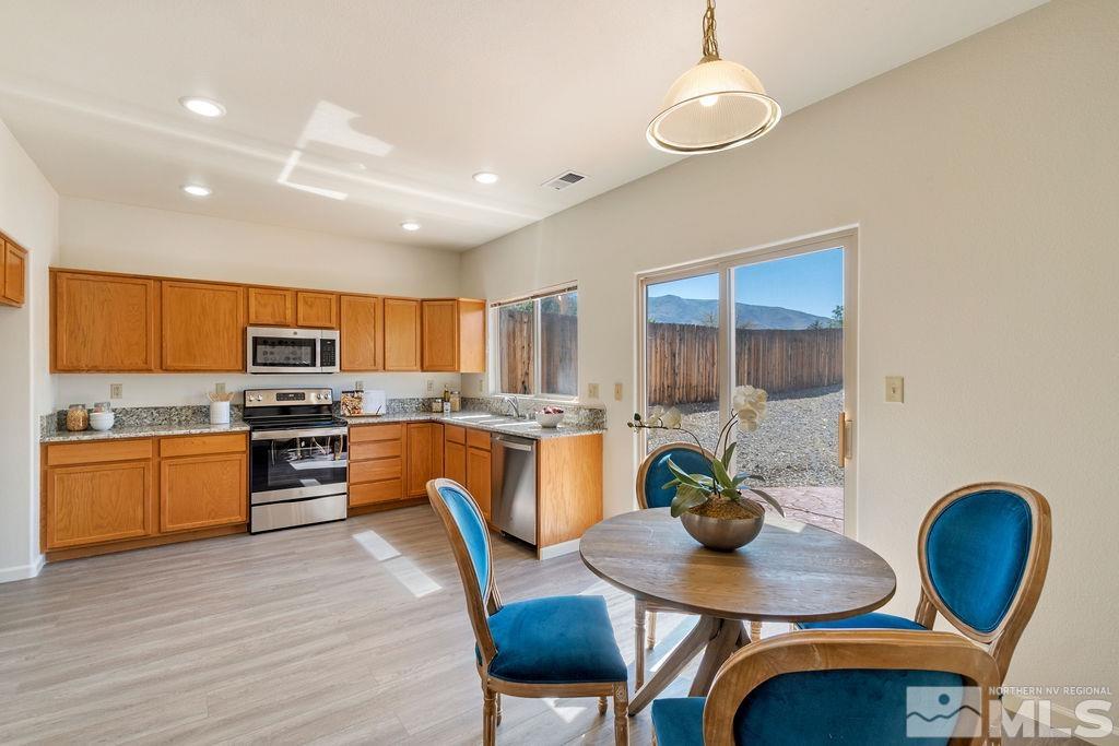 9775 Meadowstar Drive Reno, NV 89506 - Photo 12 of 30 a kitchen with stainless steel appliances granite countertop a stove a kitchen island a dining table and chairs