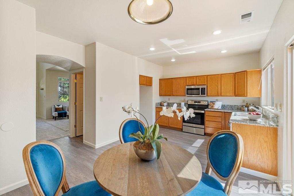 9775 Meadowstar Drive Reno, NV 89506 - Photo 13 of 30 a kitchen with stainless steel appliances granite countertop a refrigerator dining table and chairs