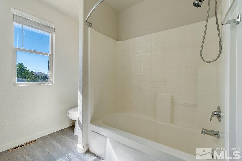 9775 Meadowstar Drive Reno, NV 89506 - Photo 24 of 30 a bathroom with a granite countertop toilet and a shower