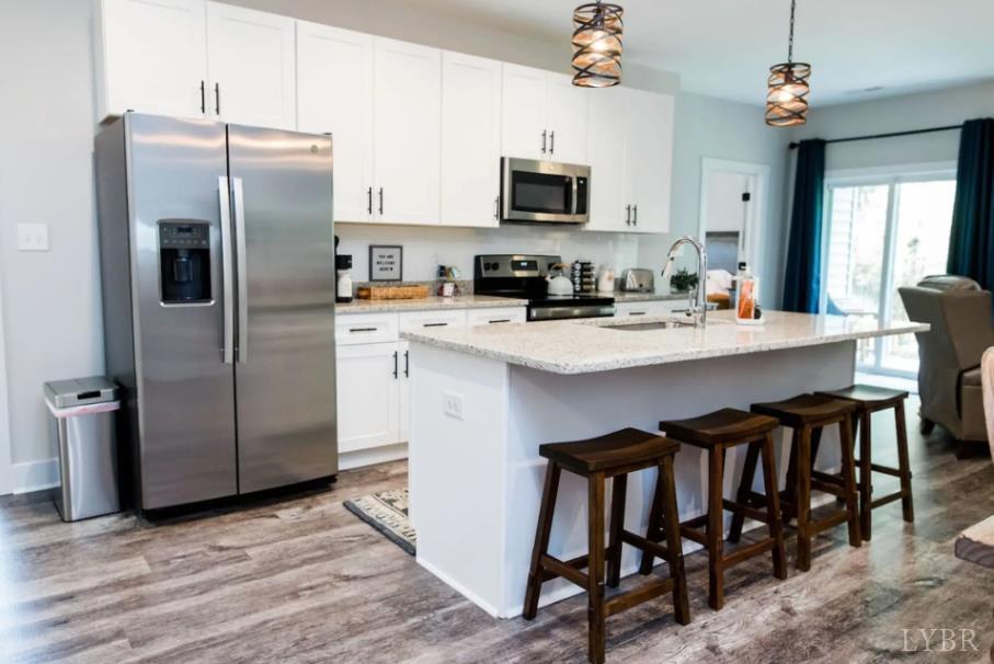 1300 Stoney Ridge Boulevard, Unit 101 Forest, VA 24551 - Photo 3 of 18 a kitchen with stainless steel appliances granite countertop a refrigerator a stove a microwave oven a sink dishwasher and a refrigerator with wooden floor