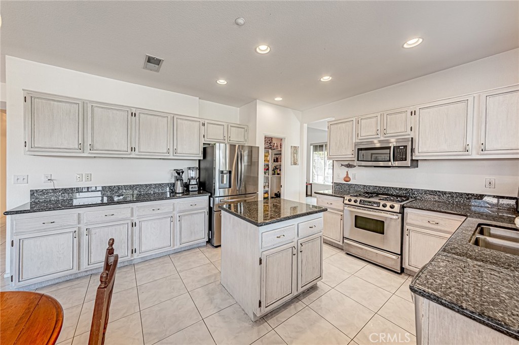 5423 Canmore Court Riverside, CA 92507 - Photo 14 of 58 a kitchen with granite countertop stainless steel appliances and white cabinets