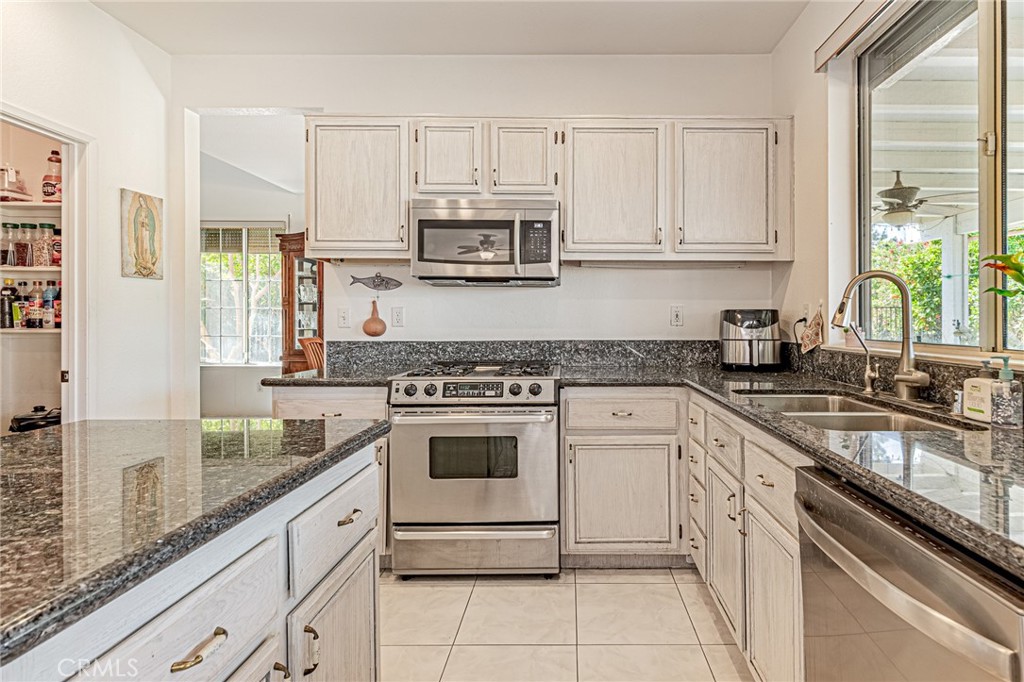 5423 Canmore Court Riverside, CA 92507 - Photo 15 of 58 a kitchen with stainless steel appliances granite countertop white cabinets a sink and dishwasher