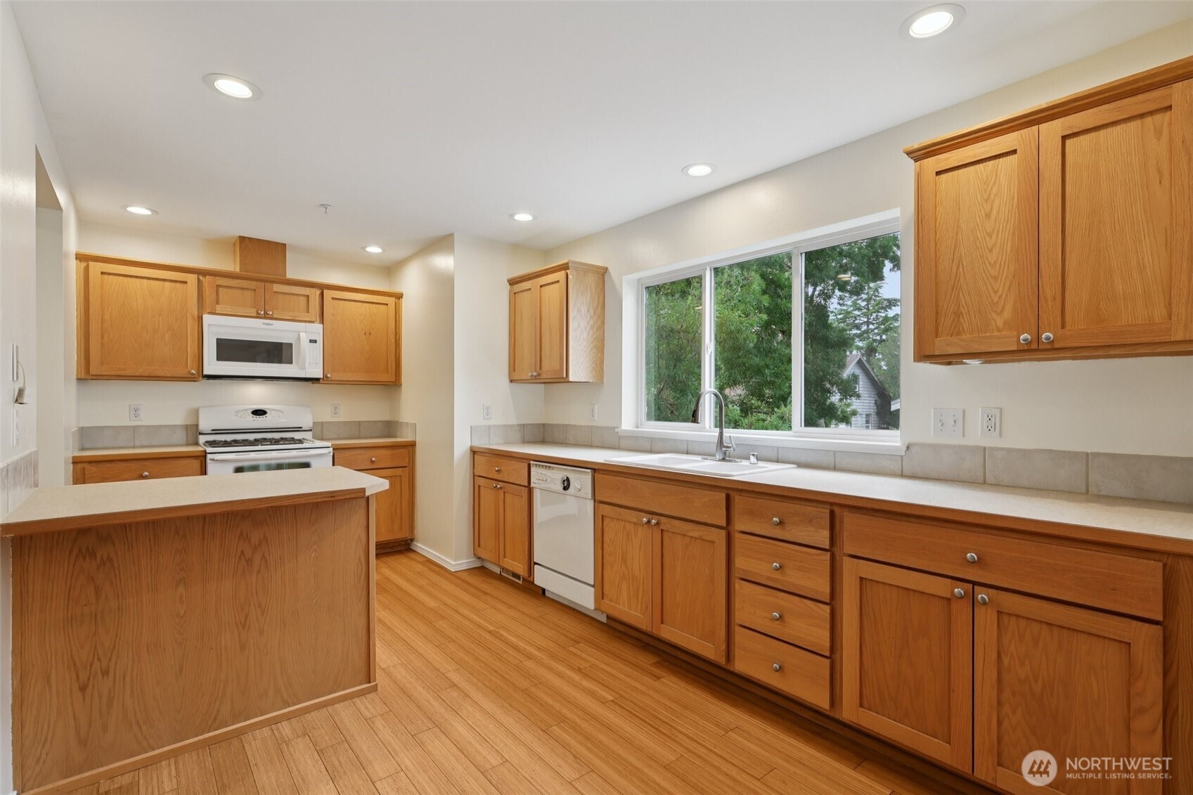 5502 240th Street Southwest, Unit C304 Mountlake Terrace, WA 98043 - Photo 11 of 30 a kitchen with stainless steel appliances granite countertop wooden cabinets a sink and a stove