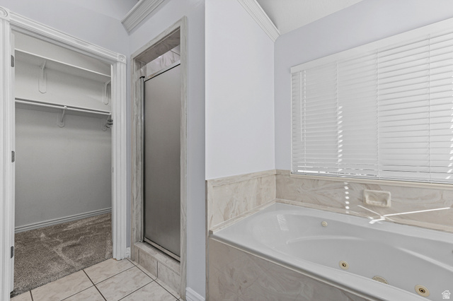 4117 North Wolf Ridge Circle Eden, UT 84310 - Photo 22 of 63 Bathroom featuring a built-in jetted tub, tiled surround, glass-enclosed shower, and a walk-in closet with carpeted flooring