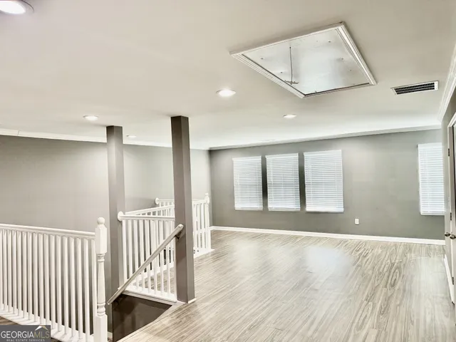 a view of an empty room with wooden floor