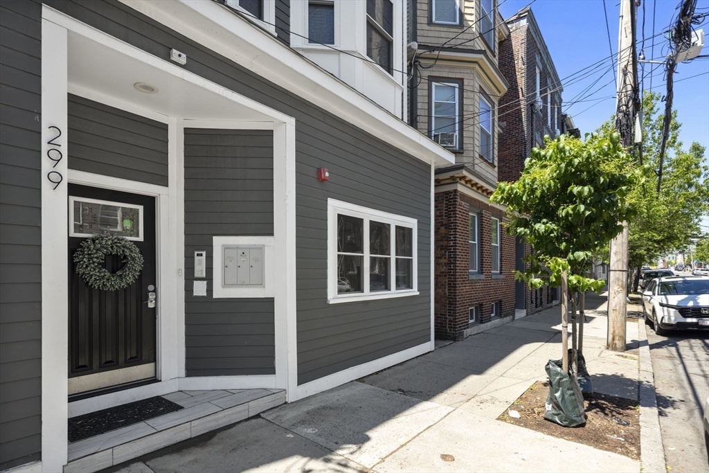 299 Sumner Street, Unit 1 Boston, MA 02128 - Photo 21 of 23 a front view of a house with a yard