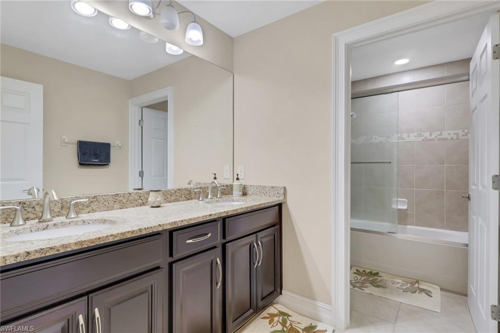 16309 Aberdeen Way Naples, FL 34110 - Photo 22 of 34 a bathroom with a granite countertop sink a mirror and a shower