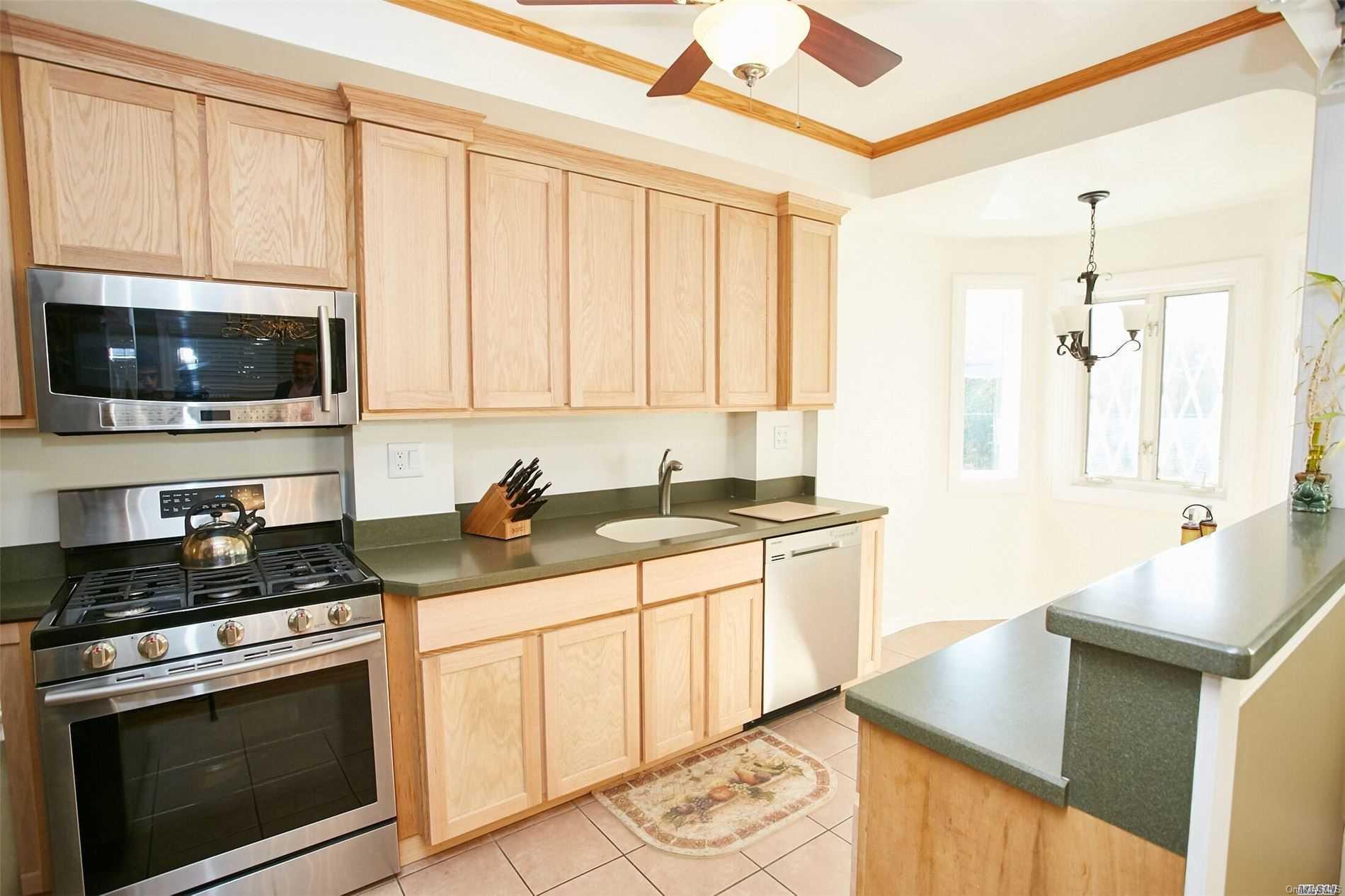 176-12 77th Road Queens, NY 11366 - Photo 8 of 20 a kitchen with stainless steel appliances granite countertop a stove a sink and a microwave
