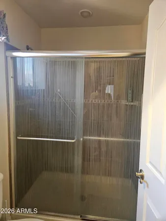 a bathroom with a granite countertop toilet and a shower