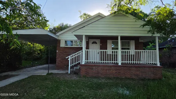a view of a house with a deck and a yard