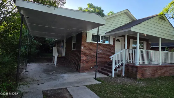 a view of a house with a small yard and wooden fence
