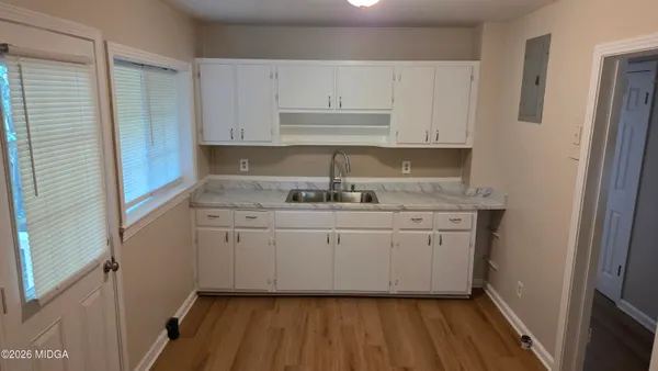 a kitchen with granite countertop white cabinets and white appliances