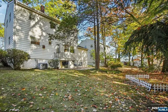 a yellow house sitting in middle of a yard