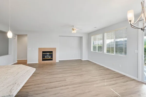 a view of a kitchen with a sink wooden cabinets and a living room