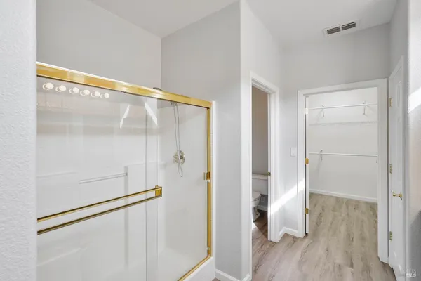 a white toilet sitting next to a shower