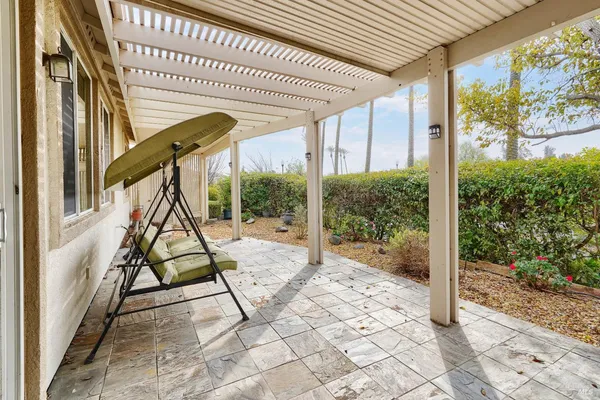 a view of a porch with a table and chairs and floor to ceiling window