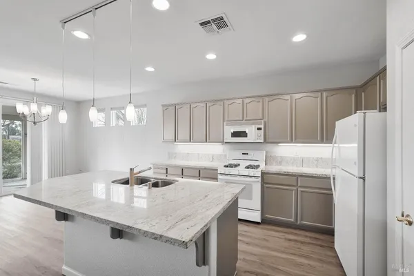 a kitchen with appliances a sink and cabinets