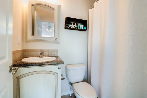 a bathroom with a toilet a sink and a mirror