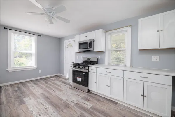 a kitchen with granite countertop a stove a sink and a window