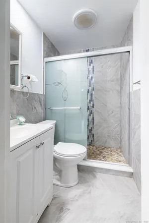 a bathroom with a granite countertop sink toilet and shower