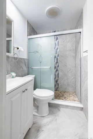 a bathroom with a granite countertop sink toilet and shower