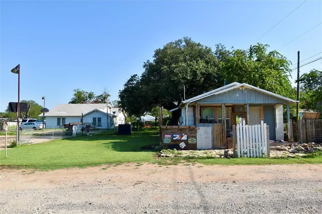 a view of a small house covered with trees in the background