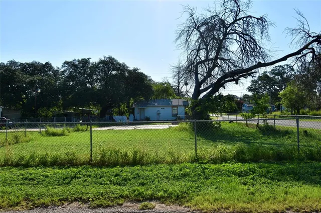 a view of a house with a big yard and potted plants