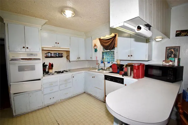 a kitchen with white cabinets and white appliances