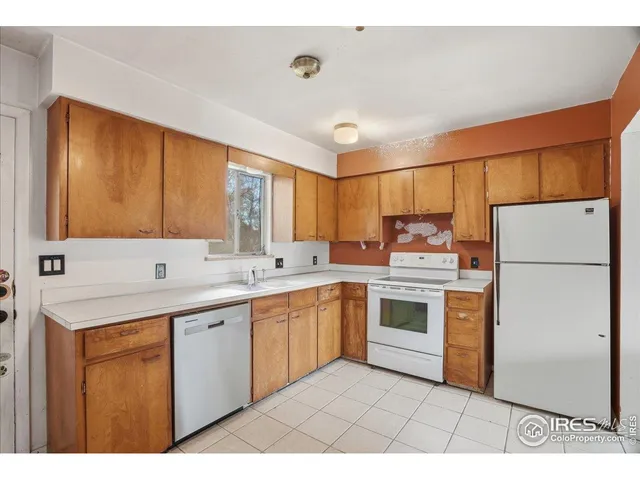 a kitchen with a sink a refrigerator and cabinets