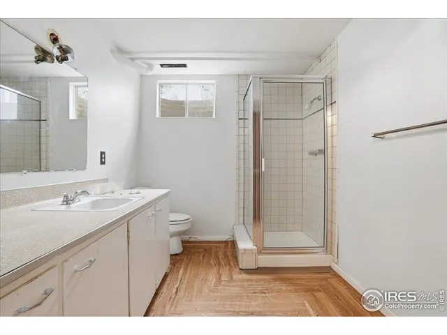 a bathroom with a sink a toilet a mirror and shower