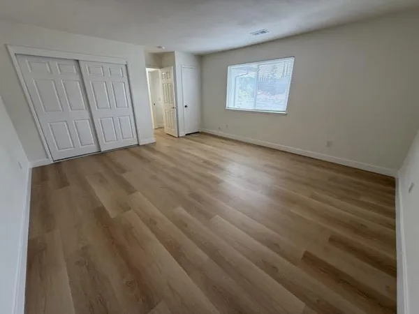 a view of an empty room with wooden floor
