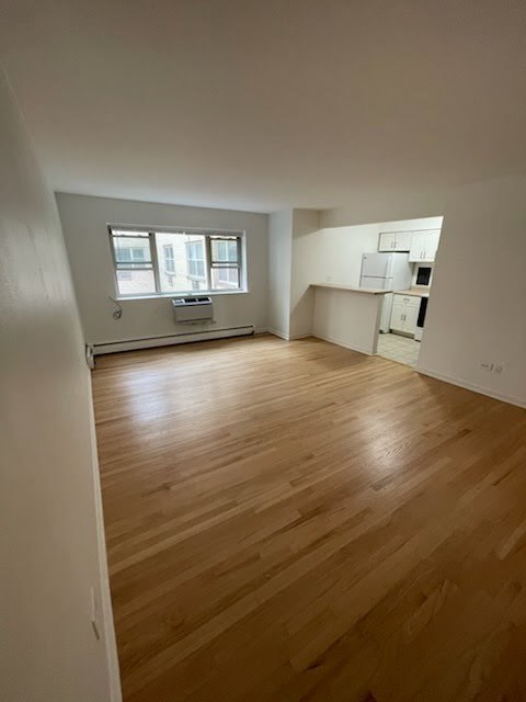 420 West Aldine Avenue, Unit 326 Chicago, IL 60657 - Photo 5 of 11 an empty room with wooden floor and windows