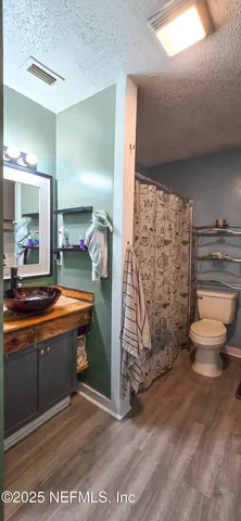 a bathroom with a sink mirror vanity and toilet