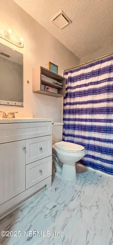 a bathroom with a sink a toilet and shower curtain