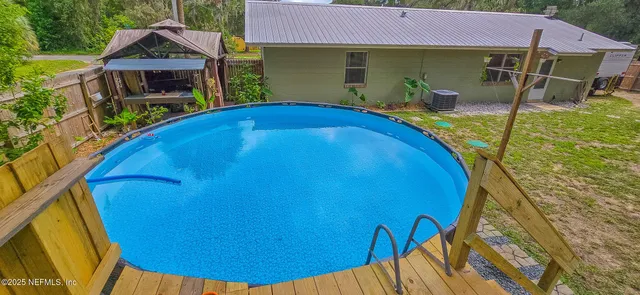 a view of a backyard with wooden fence