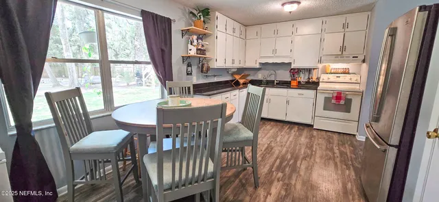 a kitchen with a table chairs refrigerator and a table