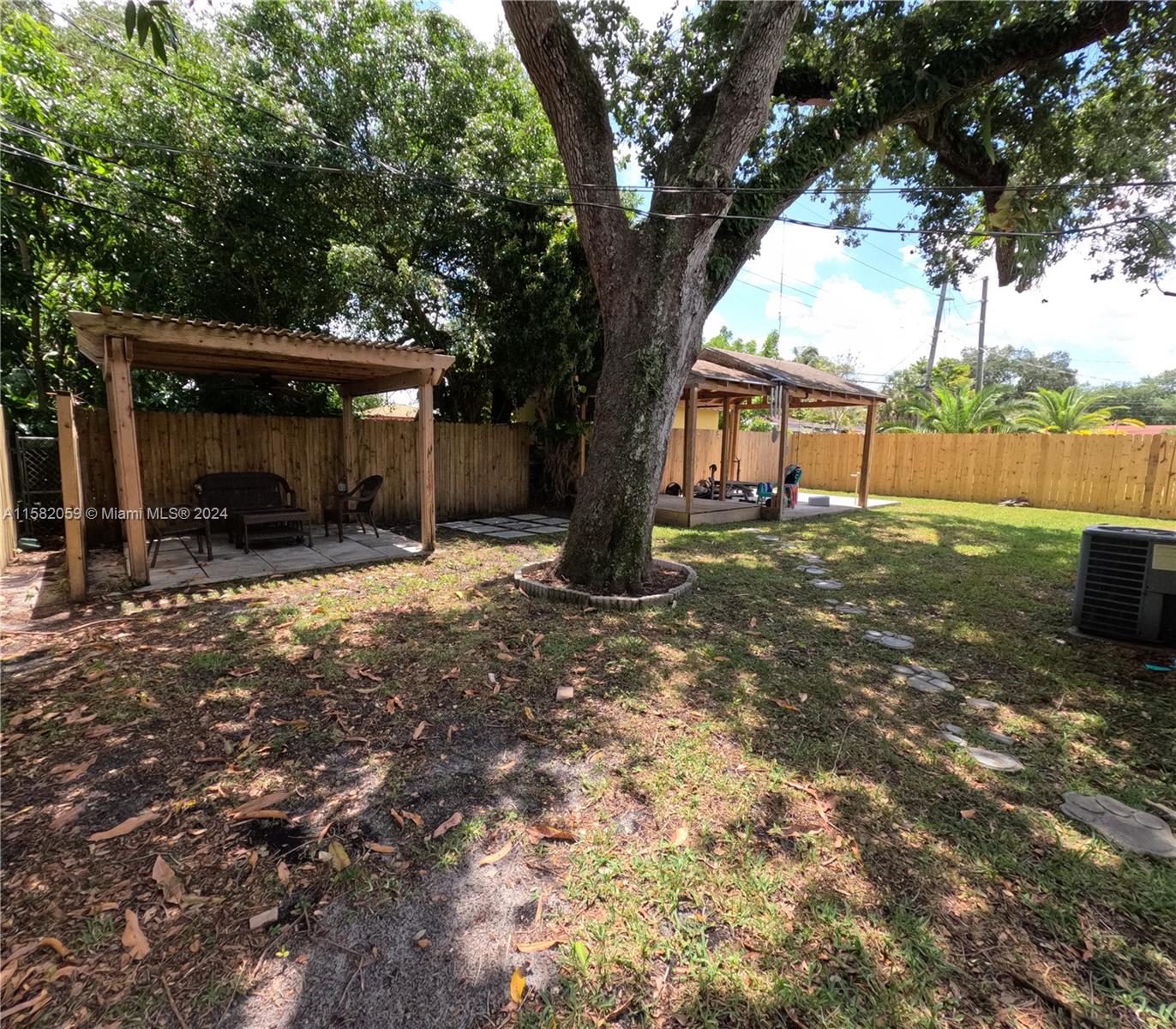 6170 Harding Street, Unit F Hollywood, FL 33024 - Photo 12 of 17 a view of a house with a yard and tree s