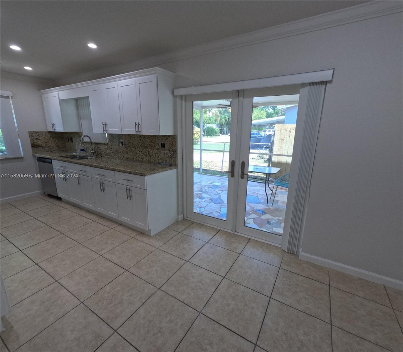 6170 Harding Street, Unit F Hollywood, FL 33024 - Photo 7 of 17 a kitchen with stainless steel appliances granite countertop a stove a sink and a refrigerator