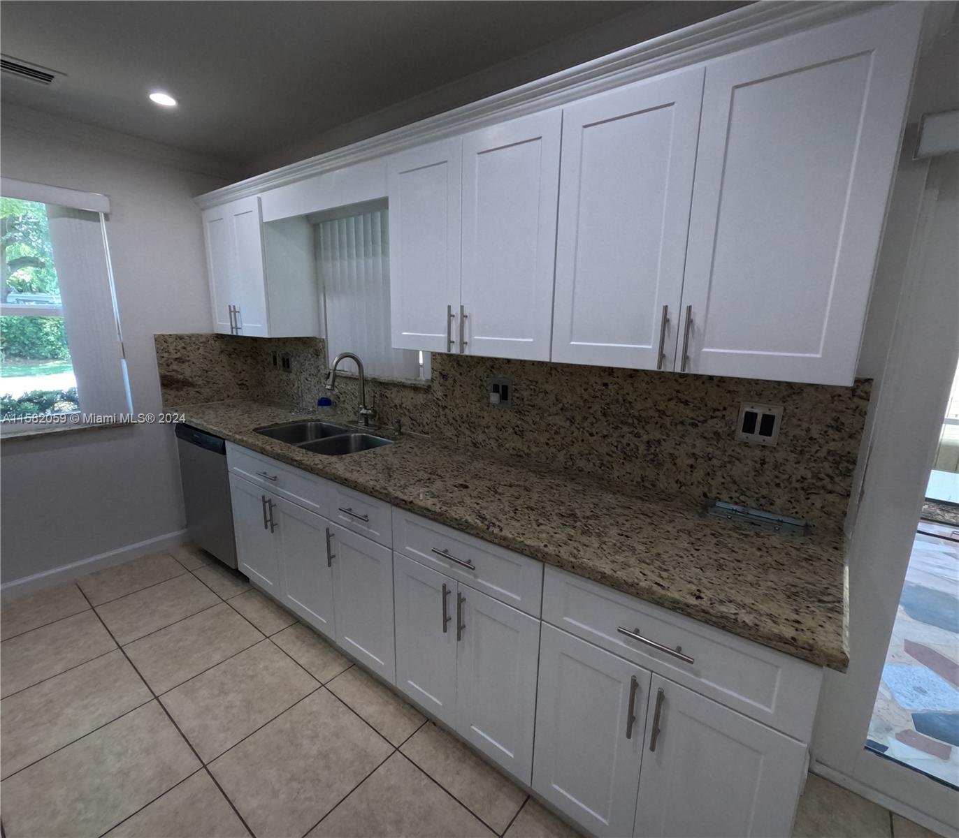 6170 Harding Street, Unit F Hollywood, FL 33024 - Photo 8 of 17 a kitchen with stainless steel appliances granite countertop a sink and a white cabinets
