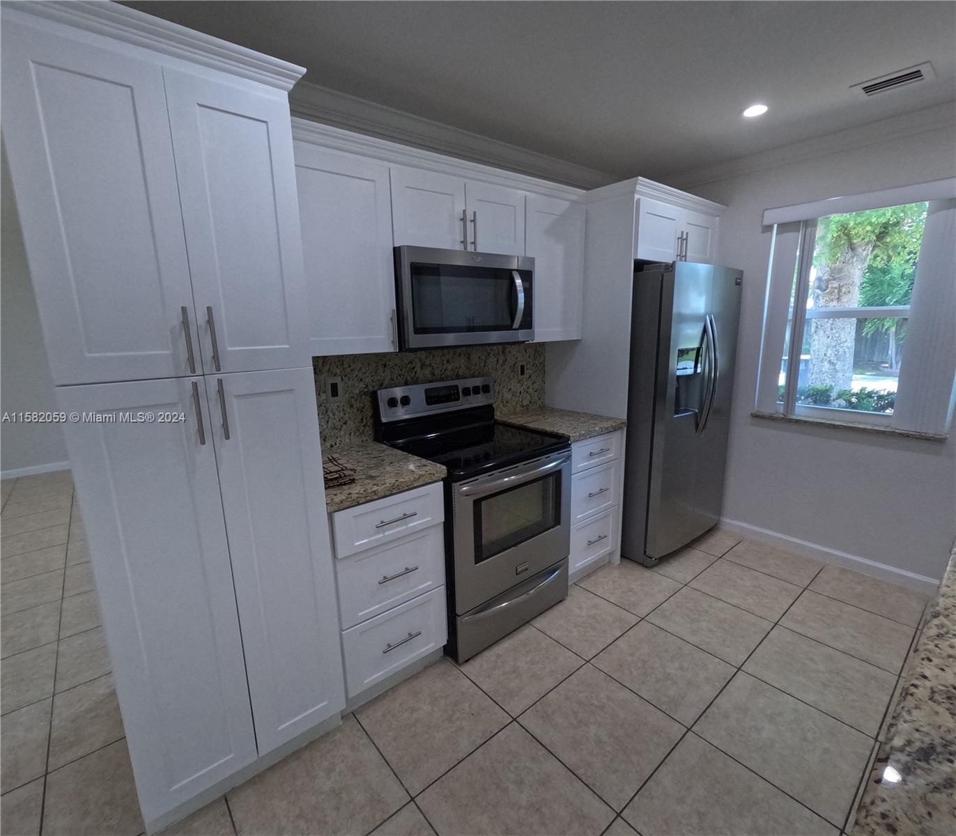 6170 Harding Street, Unit F Hollywood, FL 33024 - Photo 9 of 17 a kitchen with a refrigerator stove and microwave