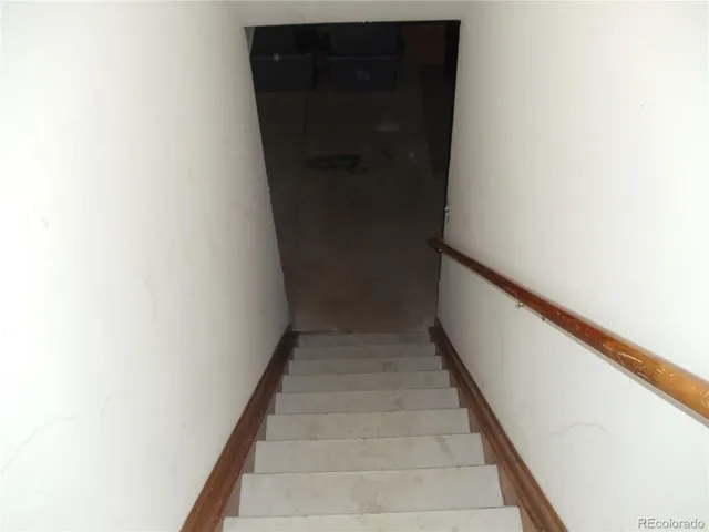 a view of staircase with white walls and white door