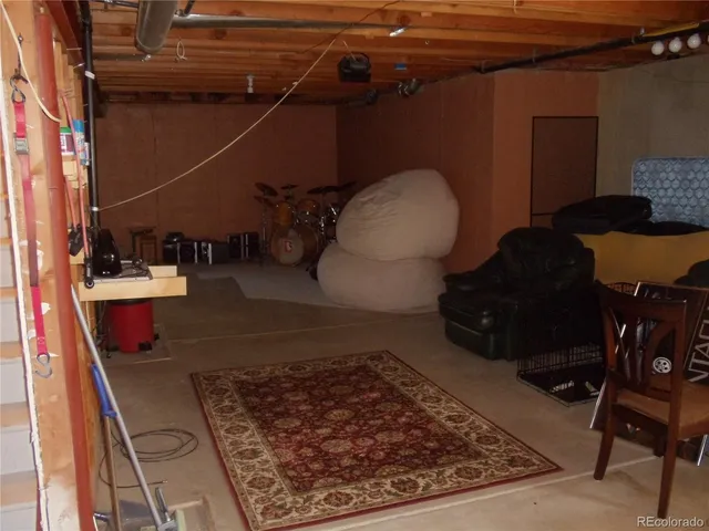 a living room with chairs and a rug