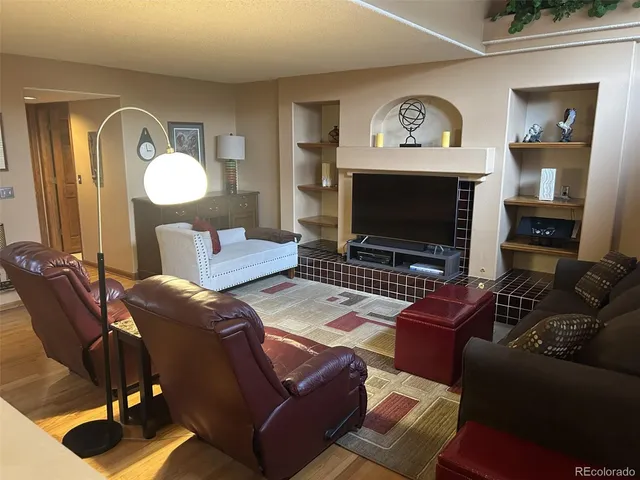 a living room with furniture a mirror and a fireplace