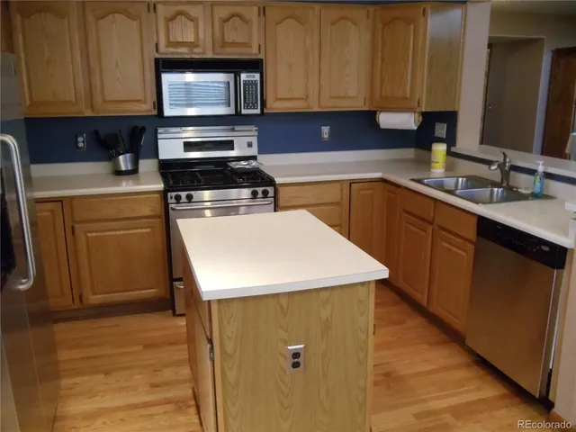 a kitchen with stainless steel appliances a stove refrigerator sink and cabinets