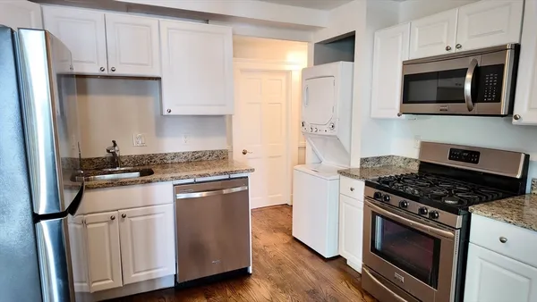 a kitchen with stainless steel appliances a stove a microwave and cabinets