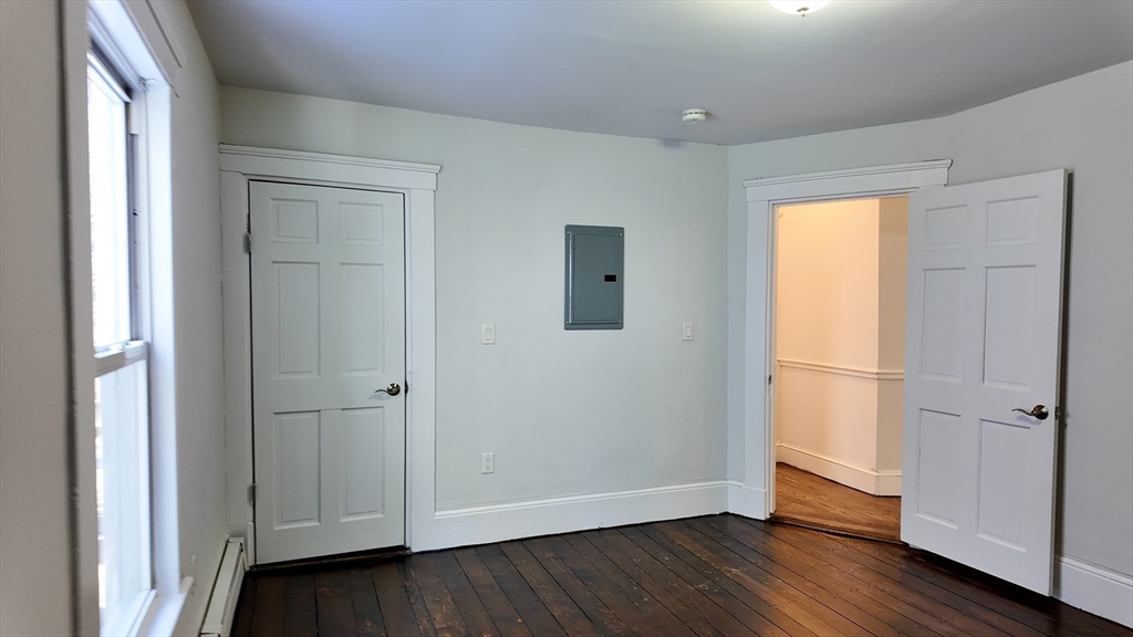 294 Windsor Street, Unit 2 Cambridge, MA 02139 - Photo 3 of 13 a view of an empty room with wooden floor and a window