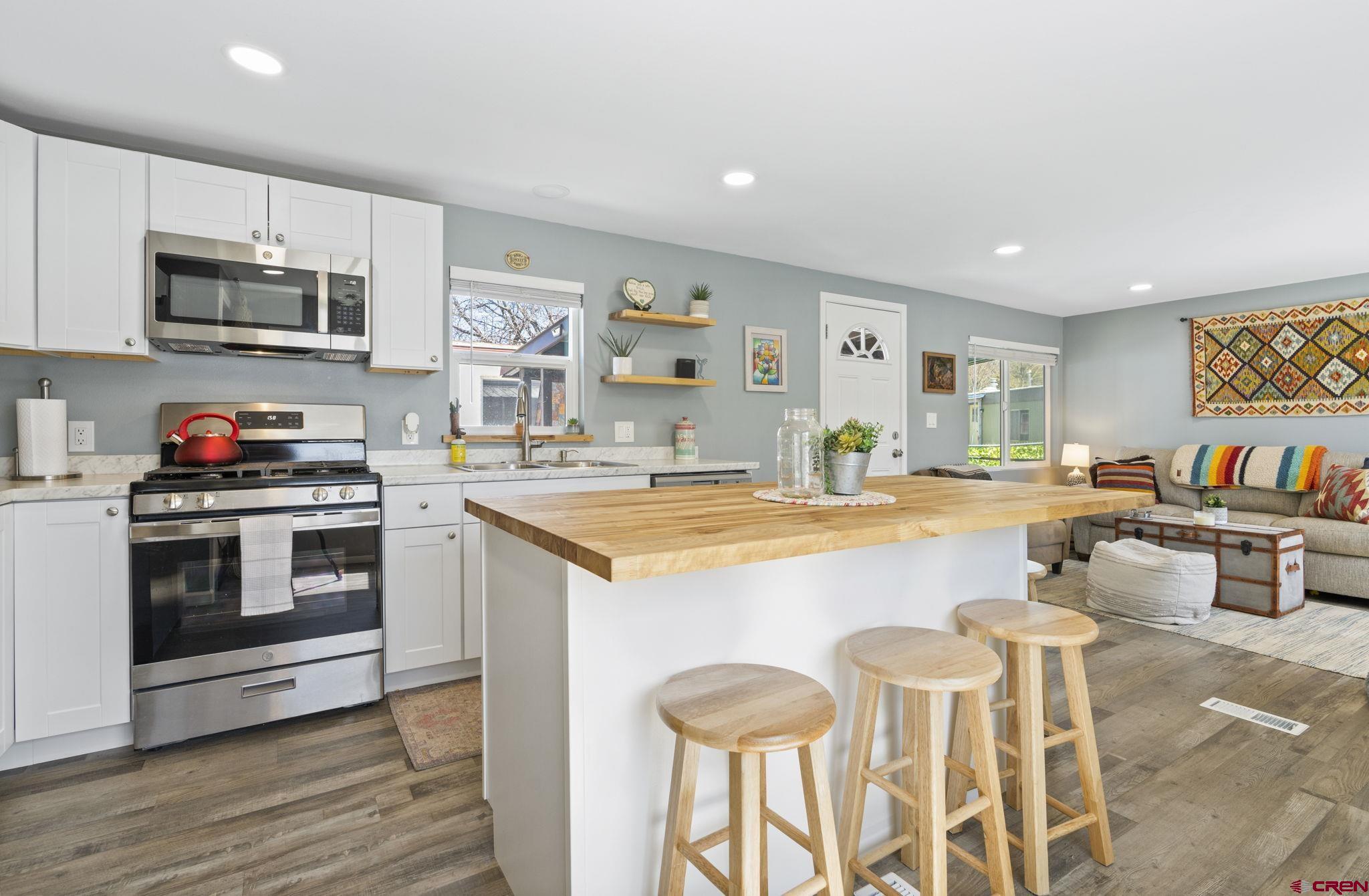 31722 Highway 550, Unit 55 Durango, CO 81301 - Photo 5 of 20 a kitchen with stainless steel appliances kitchen island granite countertop a stove and a white cabinets