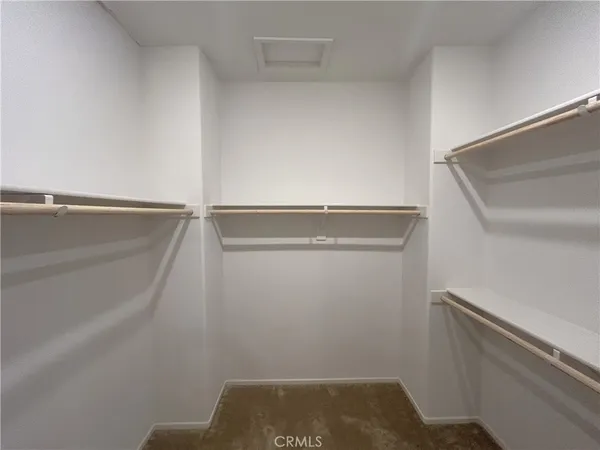 a view of a hallway with wooden floor and a living room
