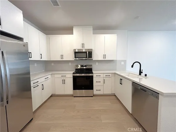 a kitchen with cabinets stainless steel appliances and window