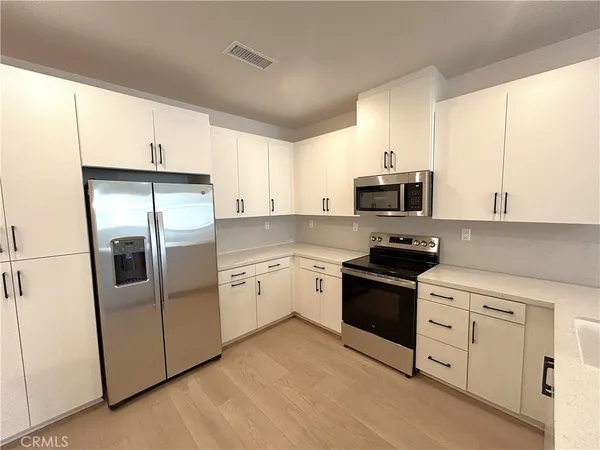 a kitchen with stainless steel appliances a stove a microwave and a refrigerator